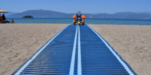 Νέα υποδομή τοποθετήθηκε στην παραλία Καραθώνας στο Ναύπλιο για την εξυπηρέτηση των ατόμων με κινητικά προβλήματα, προκειμένου, να απολαμβάνουν με ασφάλεια και ευκολία το μπάνιο τους στη θάλασσα, Πέμπτη 7 Ιουνίου 2018. Η συγκεκριμένη υποδομή αποτελείται από ένα ειδικό αμαξίδιο, το οποίο μπαίνει μέσα στο νερό με τον λουόμενο, ο οποίος το χρησιμοποιεί, καθώς και πλαστικό διάδρομο, πάνω στον οποίο μεταφέρεται το αμαξίδιο. Ο συγκεκριμένος διάδρομος τοποθετήθηκε δίπλα στον πύργο του ναυαγοσώστη στην παραλία Καραθώνας προκειμένου οι ναυαγοσώστες να βοηθούν και να επιβλέπουν την ασφαλή χρήση του αμαξιδίου. Η πρώτη επίδειξη της λειτουργίας των εγκαταστάσεων έγινε παρουσία του δημάρχου Ναυπλιέων Δημήτρη Κωστούρου και του αντιδήμαρχου Γιώργου Καχριμάνη. Ο Δήμος έχει προμηθευτεί 3 συνολικά διαδρόμους και αμαξίδια ειδικά σχεδιασμένα για άτομα με κινητική αναπηρία τα οποία και θα τοποθετηθούν τις επόμενες ημέρες στις παραλίες του Τολού και της Πλάκας Δρεπάνου. ΑΠΕ-ΜΠΕ /ΑΠΕ-ΜΠΕ/ΜΠΟΥΓΙΩΤΗΣ ΕΥΑΓΓΕΛΟΣ